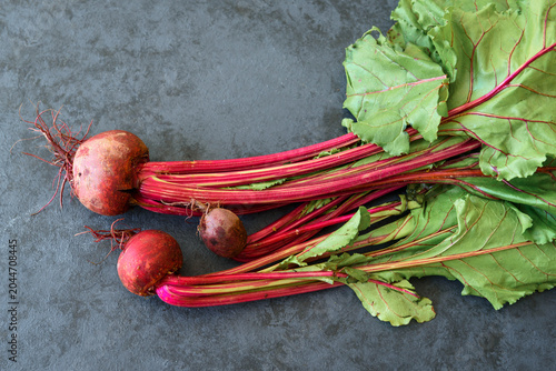 Chard with beetroots. Young beetroot with fresh leaves on dark background
