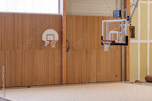 Fotografie Salle d’entraînement de basketball moderne avec sol sportif et paniers de basket, illustrant un espace intérieur dédié au sport, à l’entraînement et à la performance