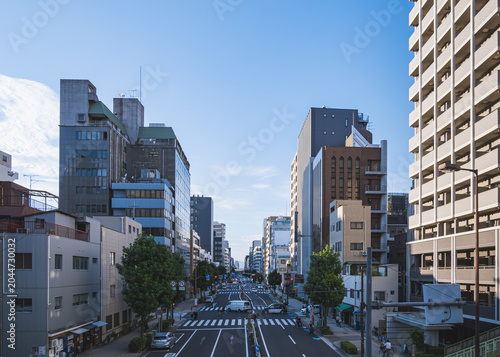 歩道橋から見下ろすオフィスビルとマンションが並ぶ都会の幹線道路