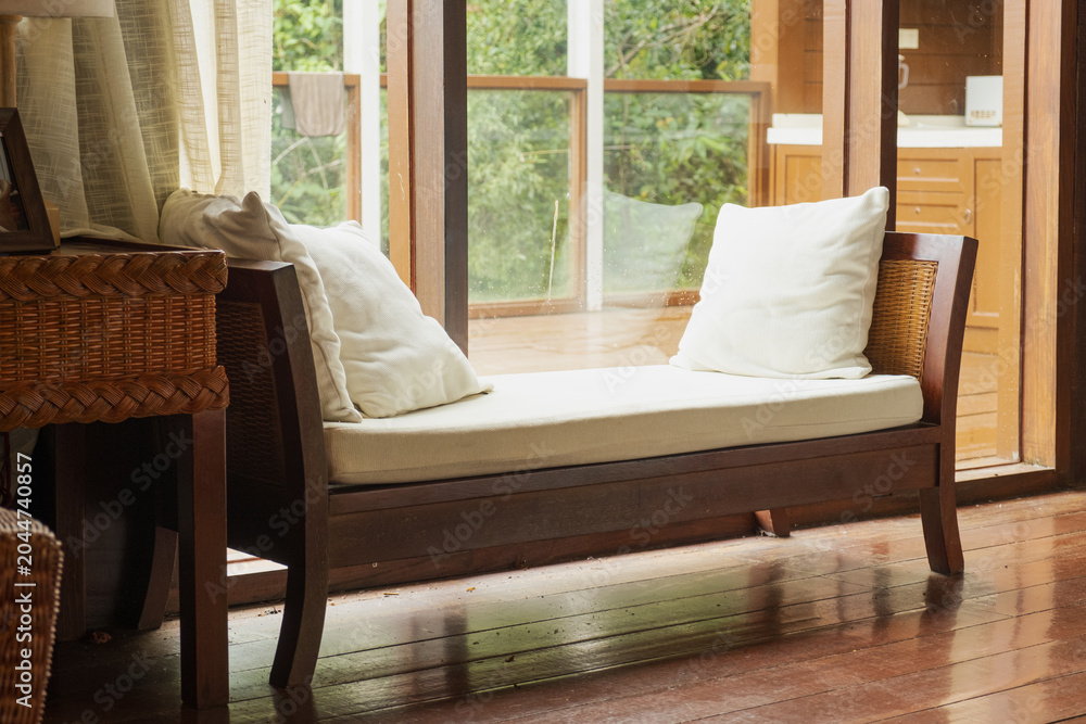 Fototapeta premium Wooden daybed with white cushions and wicker basket in tropical room
