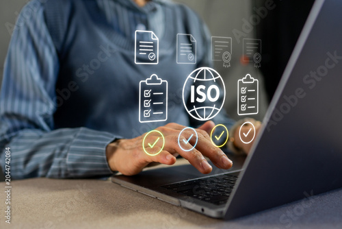 Fotografie Businessman managing ISO standard certification and quality control on laptop