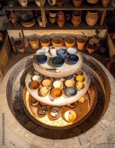 Glazed Handmade Ceramic Bowls Arranged on Kiln Shelves in Pottery Studio