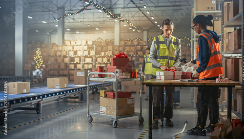 Warehouse Workers Packing Holiday Gift Boxes In Distribution Center During Seasonal Period