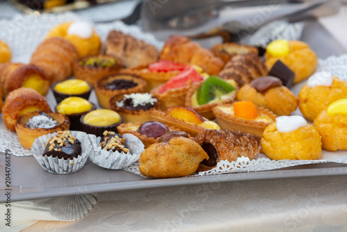 Tray displaying a variety of colorful mini pastries and desserts