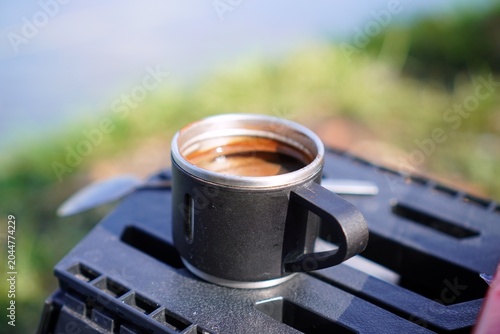 Photos Hot Espresso Coffee in Travel Mug on Outdoor Table