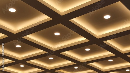 фотографія Modern interior ceiling design with square grid pattern and warm hidden LED lighting or downlights