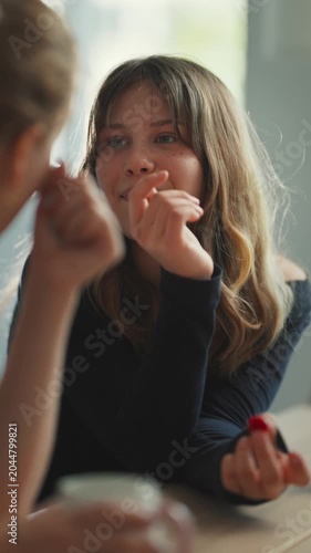 Teenage girl talking and eating berries with friend