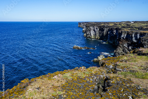 Cuadro en lienzo Rugged coastal cliffs overlooking deep blue ocean under clear sky,ICELAND