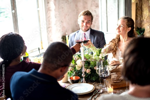 Foto Diverse group of people toasting with wine at a festive dinner table