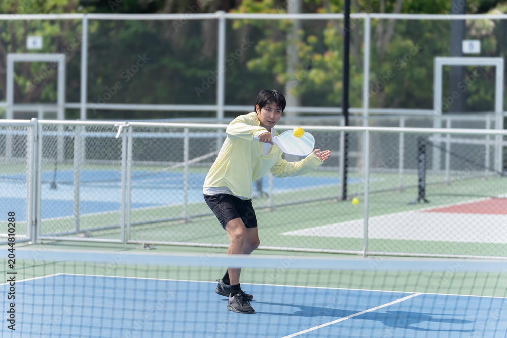 Fototapeta premium Active Diverse People Playing Pickleball on Outdoor Court