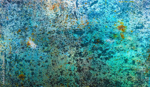 Textured surface with peeling blue paint 
