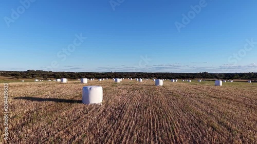 Vista aérea de pacas de ensilado encintadas en explotación agrícola durante el atardecer