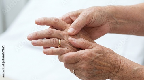 Close-up of an elderly person holding hands and massaging swollen joints