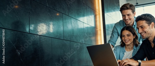 Diverse group of young professionals collaborating on a laptop in a modern office