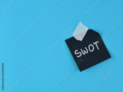 Tableau sur toile SWOT analysis word written on black note paper with adhesive tape on blue background
