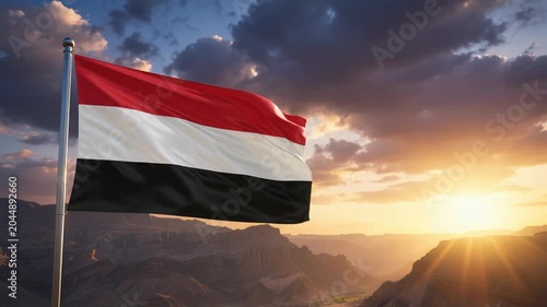 National flag of yemen waving on the wind in front of a beautiful panorama