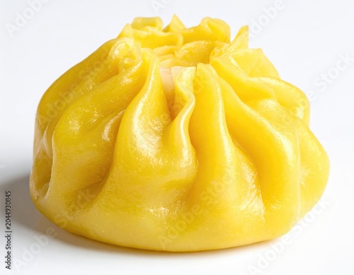 A golden-yellow, steamed dumpling with a pleated top on a white background