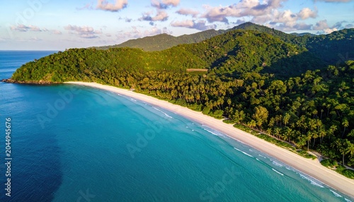 Lush, green mountains meet a pristine white sand beach and turquoise ocean