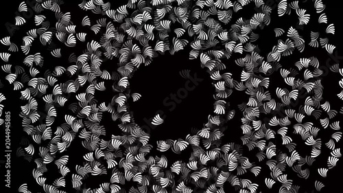 A seamless motion background of rotating white leaf-like shapes forming a circular pattern on black