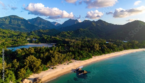 Lush green mountains meet a serene tropical coastline with a sandy beach