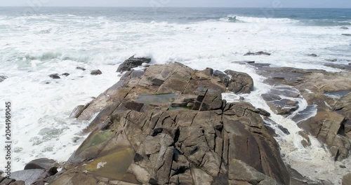 Powerful ocean waves crashing over large flat rocks The Concept of natural force