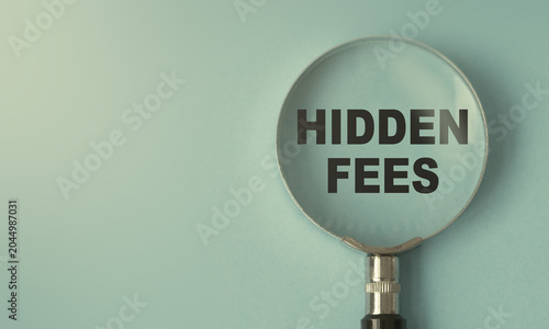 hidden fees text under magnifying glass representing business fees taxes concept and hidden costs revealed symbol design