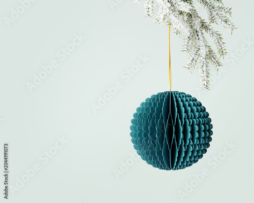 Green paper Christmas round ball, New year ornament hanging on gold string on white snow fir tree branch on mint background. Festive Christmas bauble, winter holiday decor honeycomb scandi style