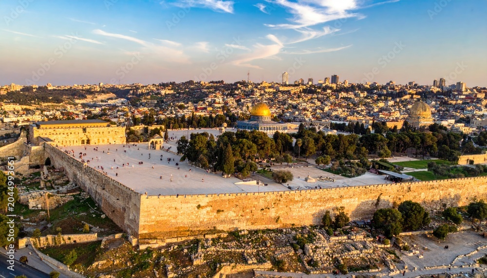Fototapeta premium Ancient walled city with golden dome and distant modern skyline