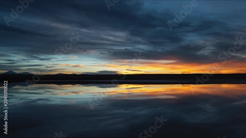 Dramatic Sunset Reflected on Calm Lake with Distant Mountains