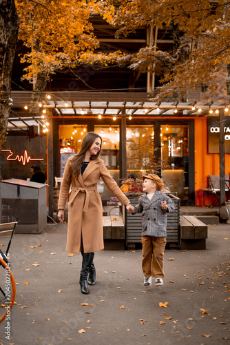 Fotografía mother and child walking in the park in autumn, mother and little son walking to