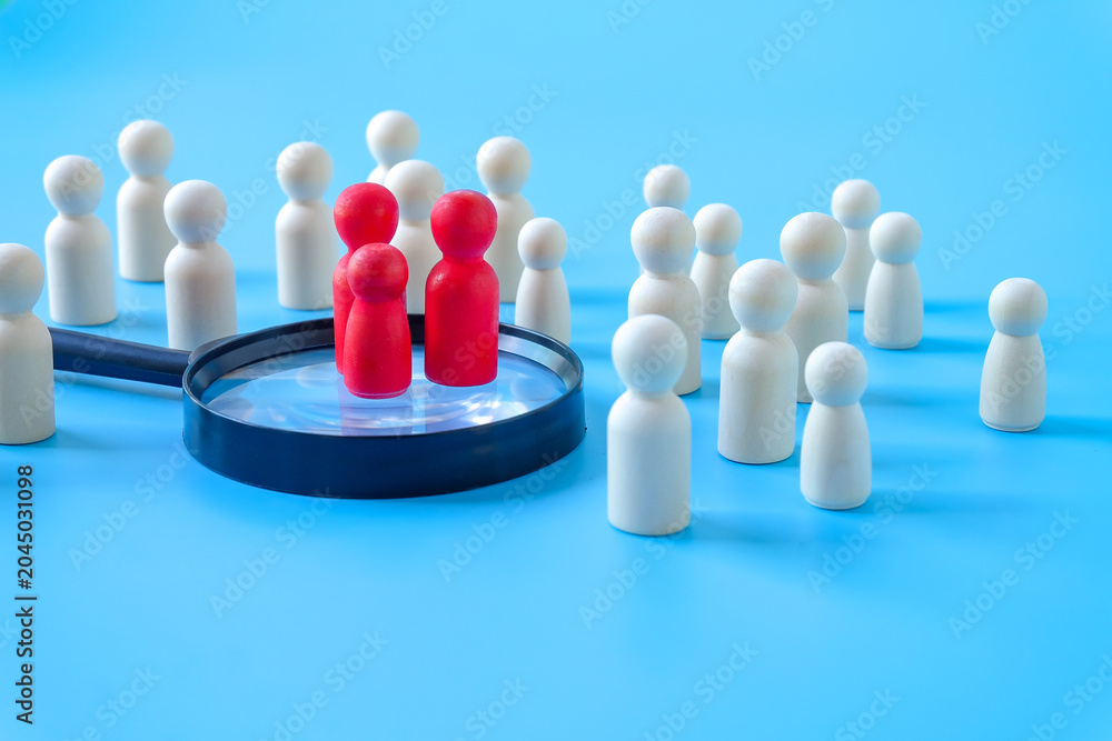 Obraz premium Wooden figures on magnifying glass,Recruitment employee concept.