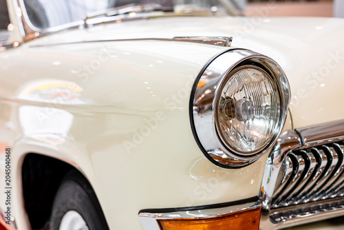 Tableau sur toile Close-up of the round headlamps of a white classic car