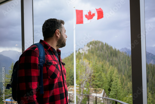 Photos Man looking at Canada flag from indoor viewpoint