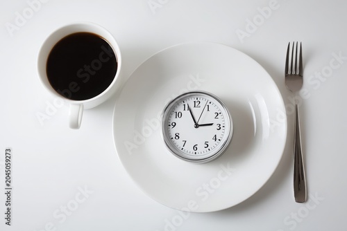 Clock Displays Time While Coffee Represents Minimalistic Fasting Routine