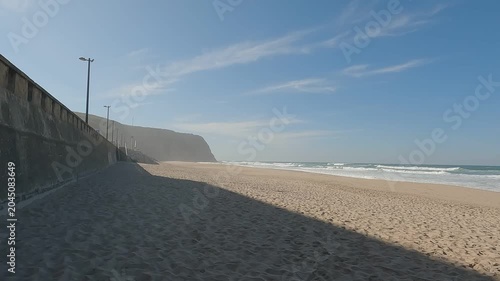 Walking on Golden Sand Beach of Praia Grande do Rodízio with Sea Cliffs and Concrete Seawall, Portugal