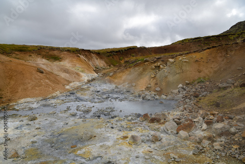 Geothermal mud stream in a barren volcanic valley
