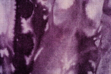 Tie dye fabric texture close up showing abstract purple detail