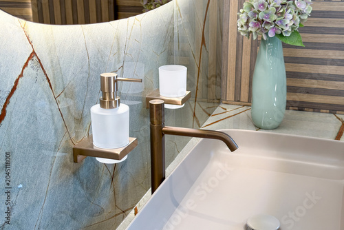 Slika na platnu Modern washroom interior design featuring basin, bronze faucet, and accessories