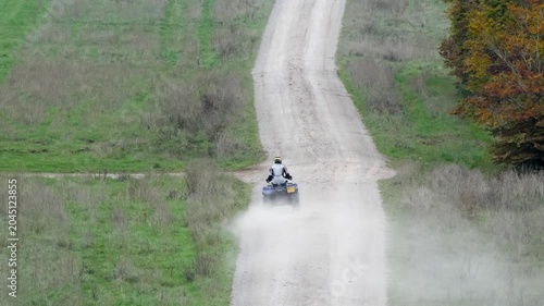 a quad biker riding his off-road quad bike along a stone track open countryside