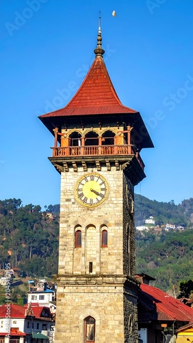 Historic Stone Clock Tower Standing in Hill Town Under Clear Blue Sky