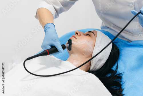 Canvas Print Modern RF lifting facial therapy for young woman in aesthetic medical center