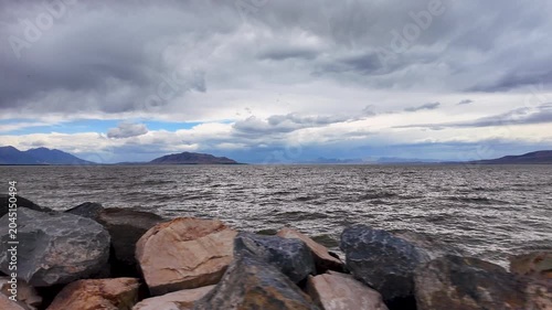 Driving along Utah Lake looking over the rocks at waves moving in slow motion.