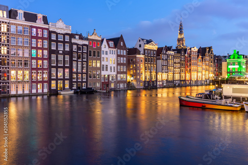 Traditional Dutch architecture facing Damrak canal and Old church tower at sunset, Amsterdam, Netherlands