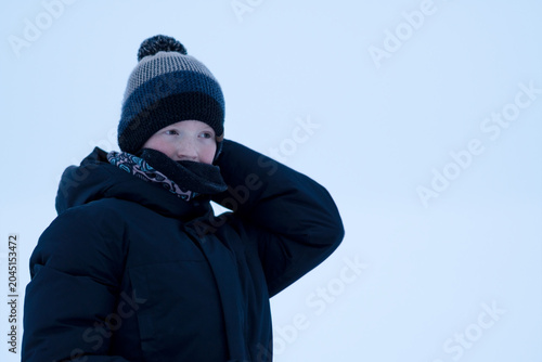 Quadro em tela A teenager in winter clothes against a snowy winter backdrop of the sea