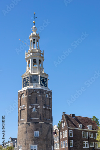 Foto A stunning view of Amsterdam's historic tower, the Montelbaanstoren, set against a clear blue sky, captured during a scenic canal tour