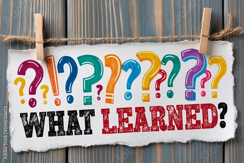 Colorful Question Marks and What You Learned Sign Hang on Wooden Wall for Education and Discovery Theme