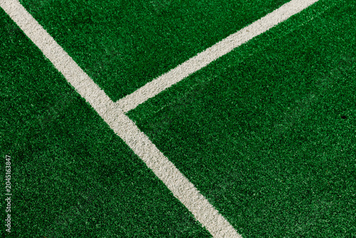 Fotografie Close up view of white painted lines forming a boundary on a bright green artificial grass sports field