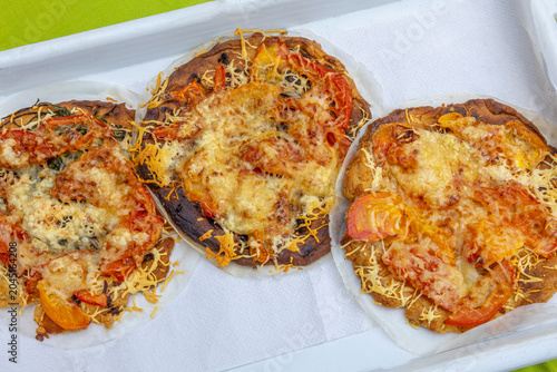 Three Pizzas With Cheese and Vegetables on a Tray