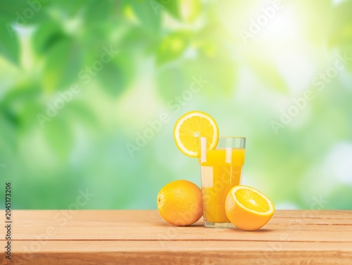 Fresh orange juice in a glass on a wooden table in nature