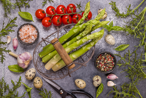 Fresh asparagus, cherry tomatoes, and quail eggs preparing spring meal